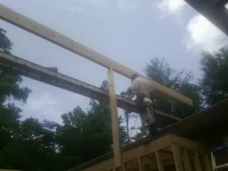 Carpenter setting a ridge beam over a new addition frame — Ice Dam Removal by Roofing Brothers in Beechgrove