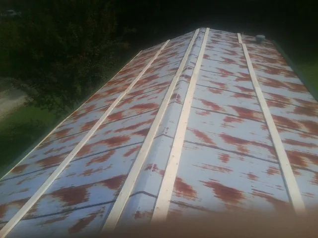 Rusted metal roof panels with new wood purlins before replacement — Storm Damage Roof Repair in Beechgrove by Roofing Brothers